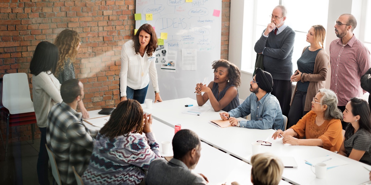 A young Black woman leads her team in a project meeting