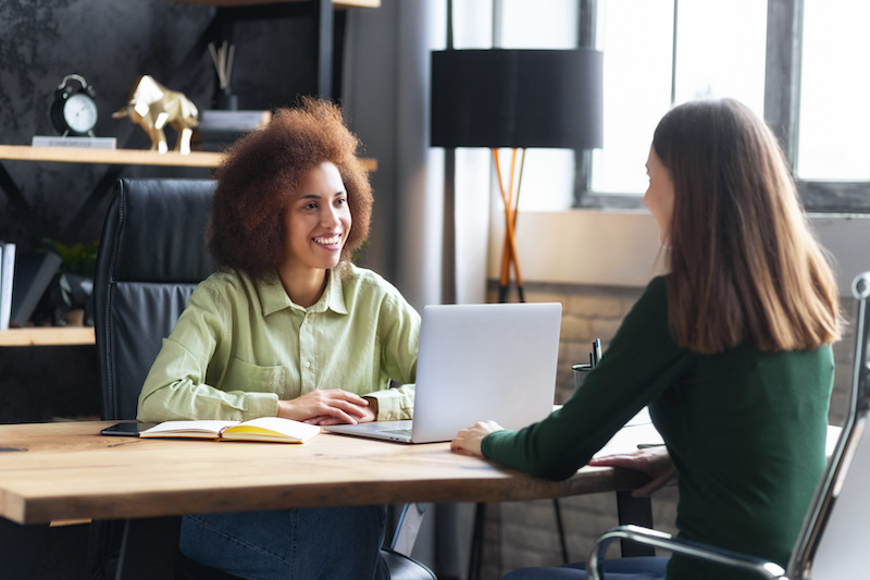 A young Black woman leads her team in a project meeting