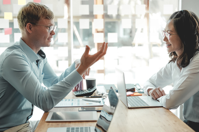 A male employee meets with his female manager to go over 360 review feedback