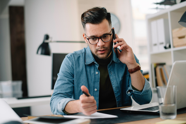 A male manager who knows how to reject an interviewee follows a script while on a call with a candidate.