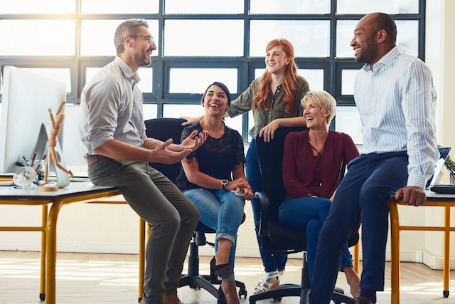 A young Black woman leads her team in a project meeting