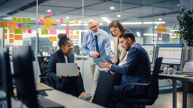 A young Black woman leads her team in a project meeting
