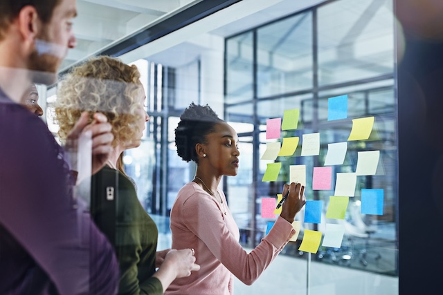 Business team organizes business objectives on sticky notes to create a plan