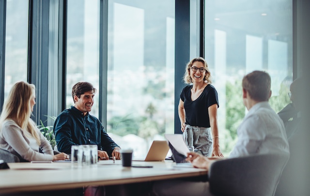 A female supervisor leads a team meeting in a conference room