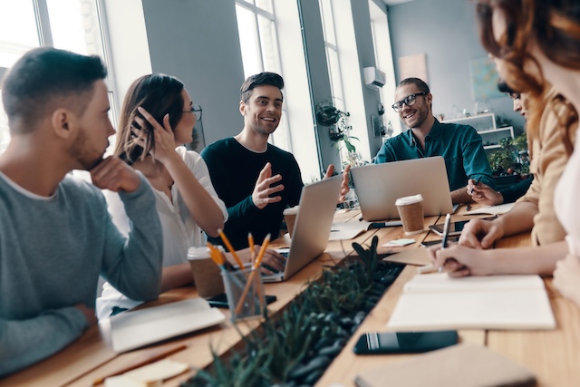 Group of young employees work together at a conference room table