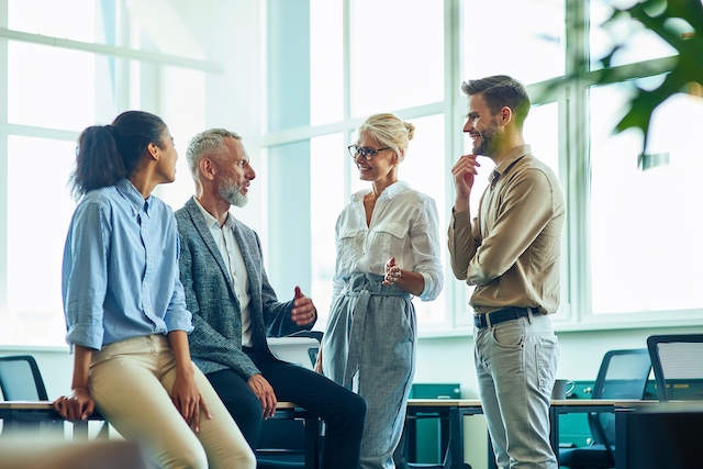 A young Black woman leads her team in a project meeting