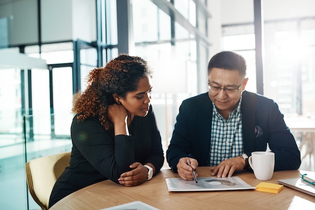 A young Black woman leads her team in a project meeting
