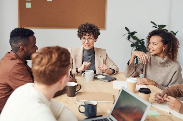A female manager leads a meeting with several team members