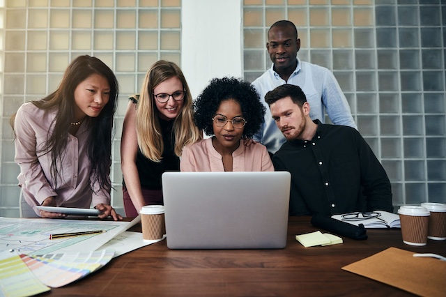 A young Black woman leads her team in a project meeting