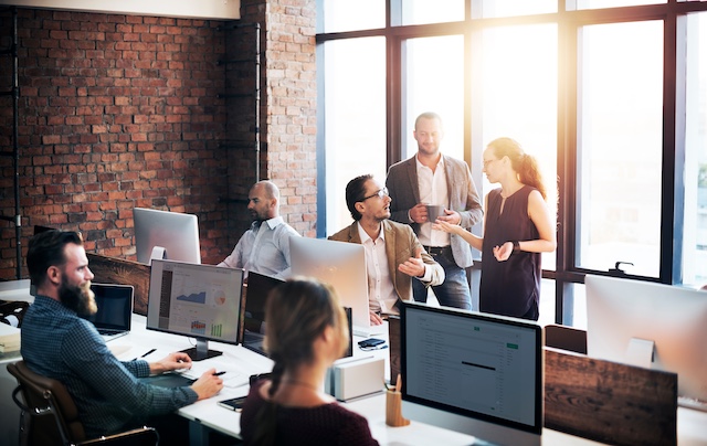A young Black woman leads her team in a project meeting