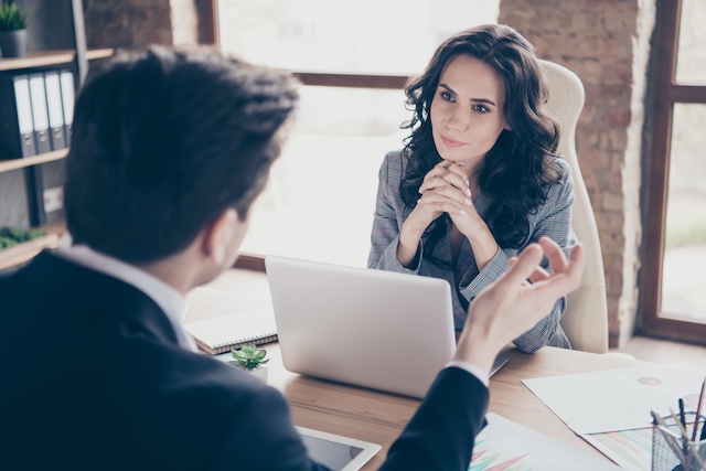 A woman actively listens to her male colleague