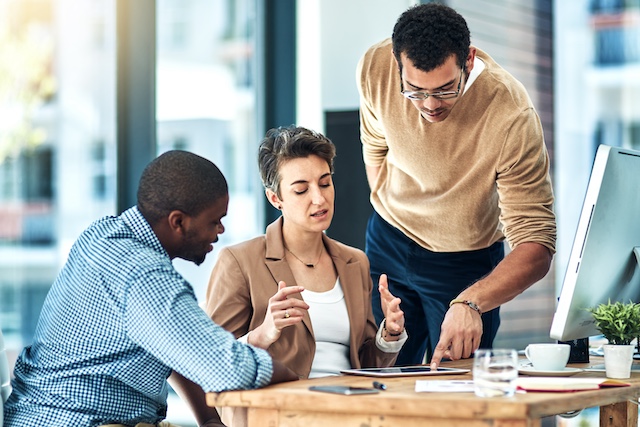 A young Black woman leads her team in a project meeting