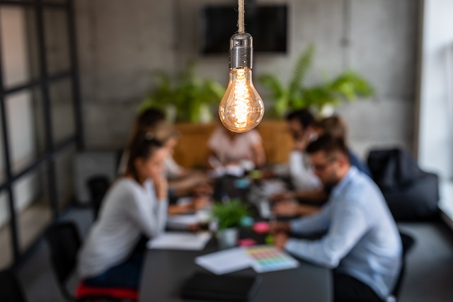 A young Black woman leads her team in a project meeting