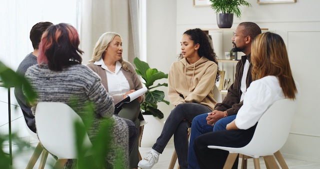 A manager talks with her diverse team to address layoff anxiety